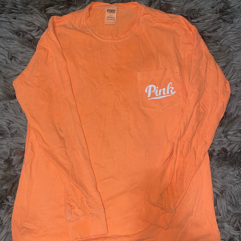 Flash on & off pictures of an orange Victoria Secret Pink long sleeve shirt